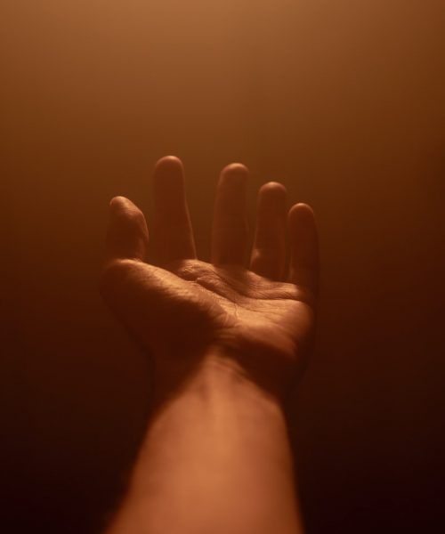 persons right hand doing peace sign